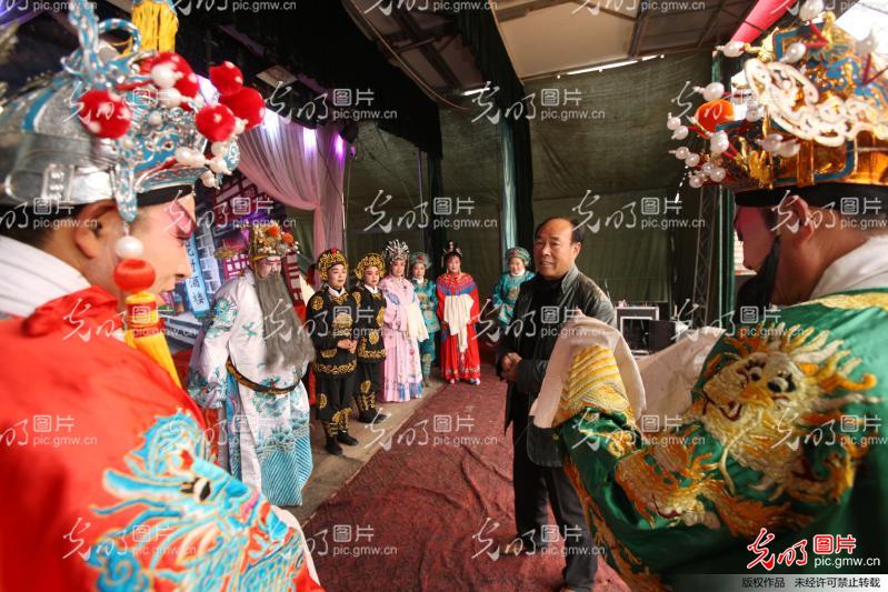 2015年11月9日,安徽省蒙城县三义镇岗河村村头,村民们围坐在简易的舞台旁,津津有味地欣赏着洪敏泗州戏剧团演出的泗州戏《刘荣铡太师》。在当地,说起洪敏泗州戏剧团和他们演出的泗州戏,村民们禁不住要夸上一番。 今年62岁的朱洪敏是三义镇的农民,吹拉弹唱样样精通,曾是县曲艺队的一员。八十年代,在县曲艺队解散后回乡成立唢呐班,带着几个人开始靠吹唢呐闯市场。在乡村奔波的多年里,朱洪敏耳闻目睹了乡村的变化和农民群众对传统文化,尤其对地方戏曲的强烈需求,他觉得如果能够成立一个自己的剧团,既能把当地群众喜爱的泗州戏传唱