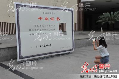 浙江杭州:大学生创意毕业证书前留下毕业回忆